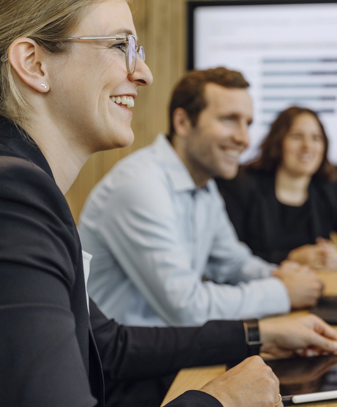 Drei Consultants sitzen in einem Meeting.