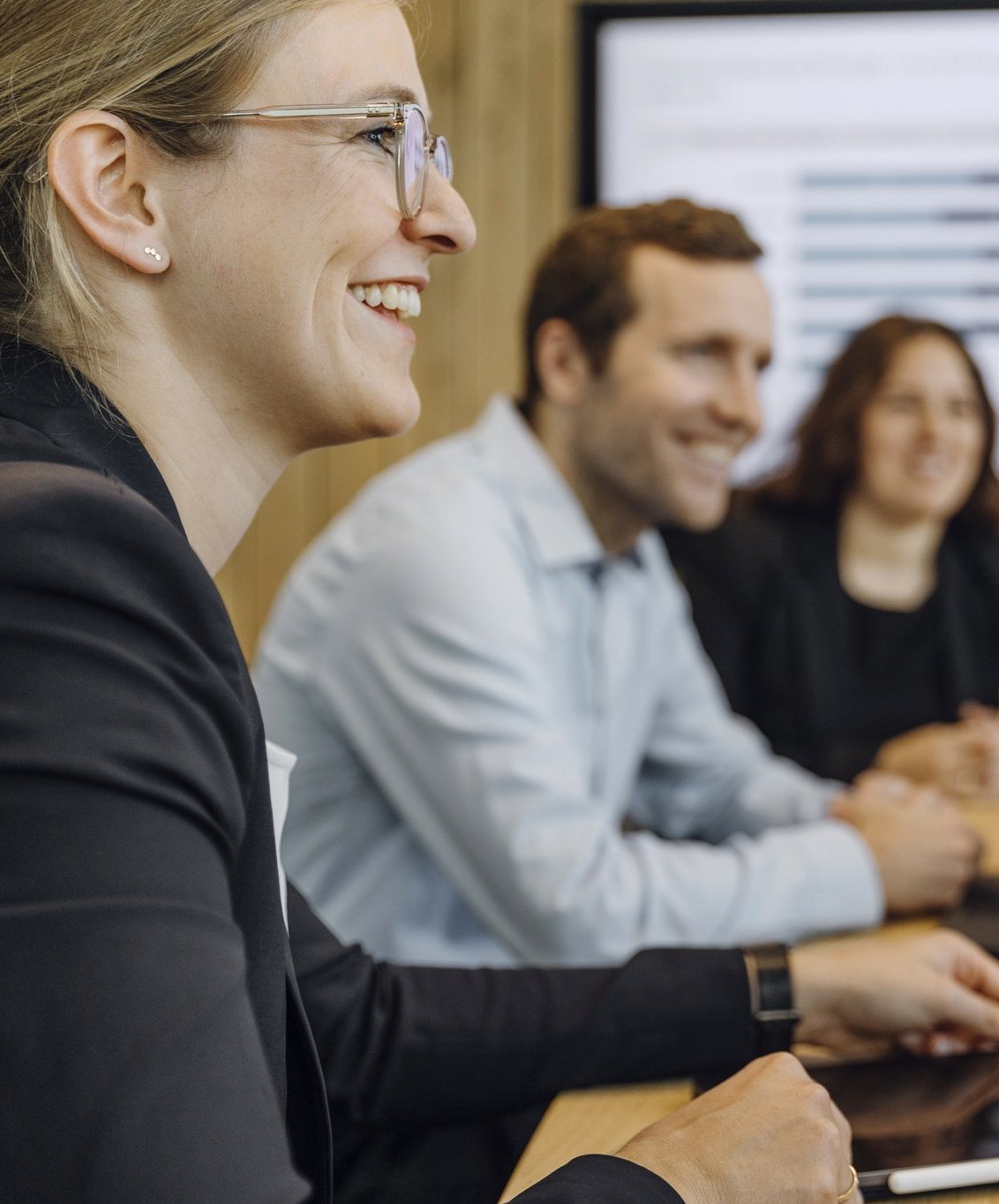 Drei Consultants sitzen in einem Meeting.