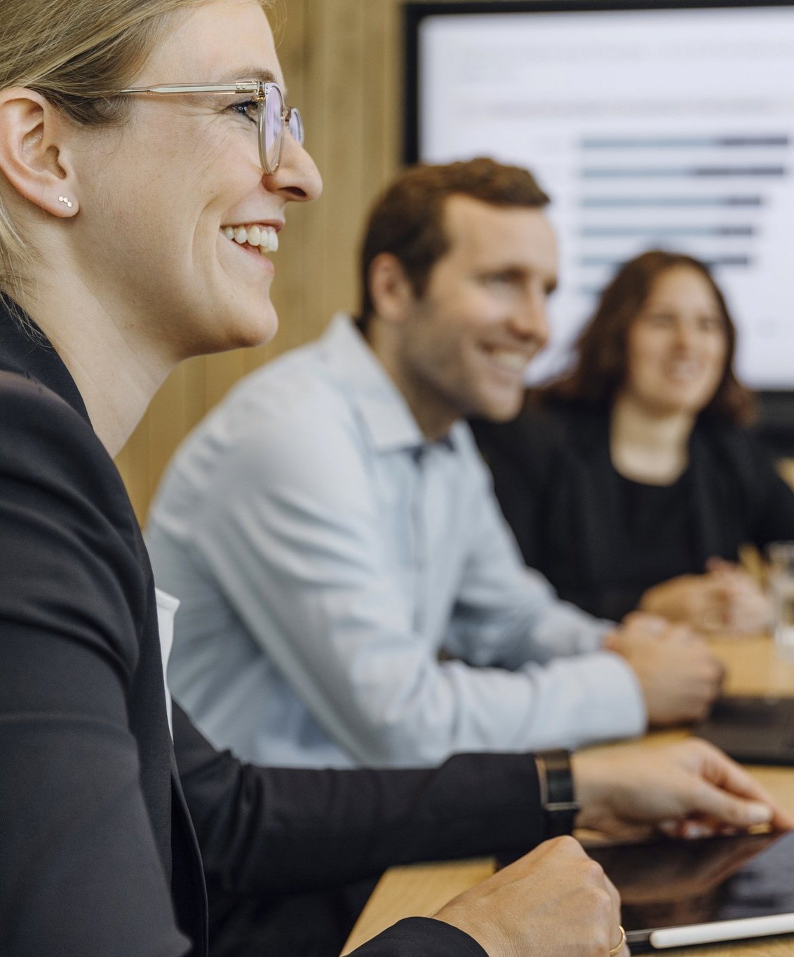 Drei Consultants sitzen in einem Meeting.
