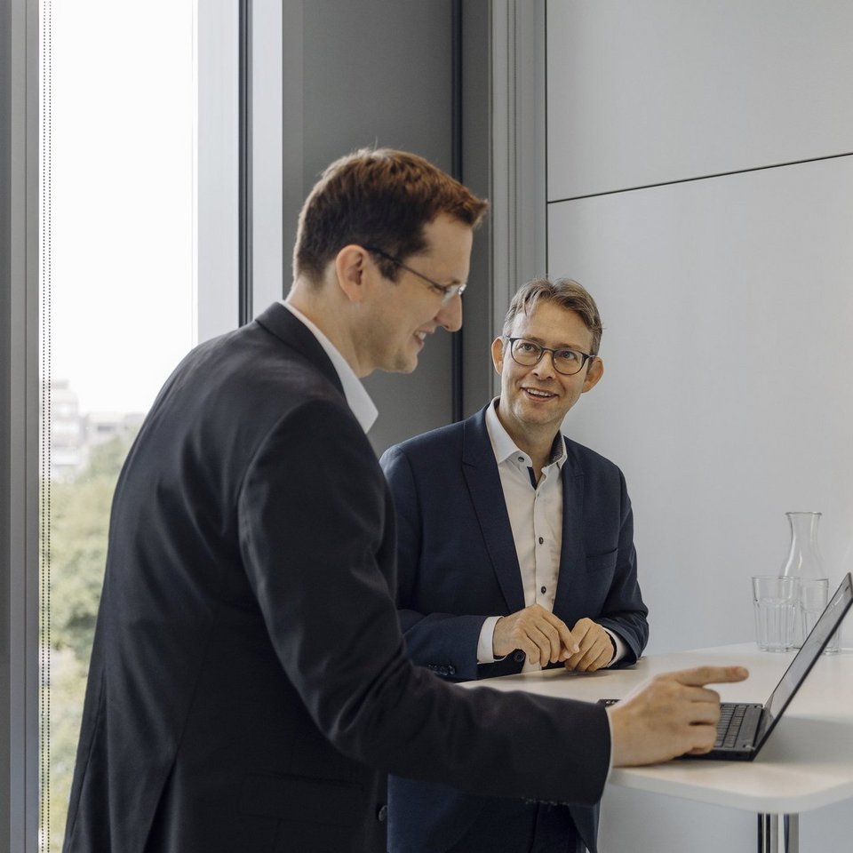 Ein Partner und ein Manager unterhalten sich in einem Meetingraum.
