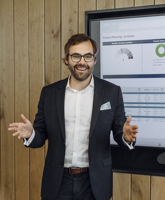 Ein Consultant stellt seinem Team eine Präsentation auf einem Smart Hub vor.vor.