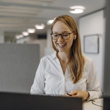Eine Junior Consultin sitzt an ihrem Arbeitsplatz.