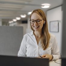 Eine Junior Consultin sitzt an ihrem Arbeitsplatz.