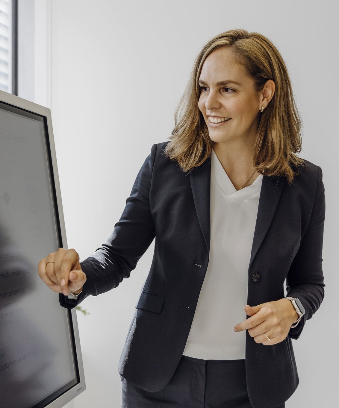 Eine Beraterin erklärt ihre Strategie auf einem interaktiven Bildschirm.