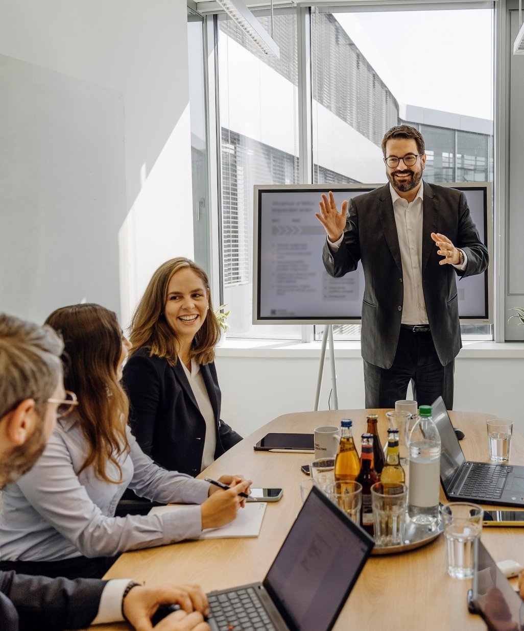 Ein Consultant erklärt enthusiatisch einem Team von Beratern seine Strategie.