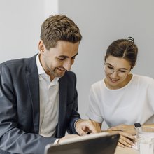 Zwei Consultants schauen gemeinsam auf ein iPad.